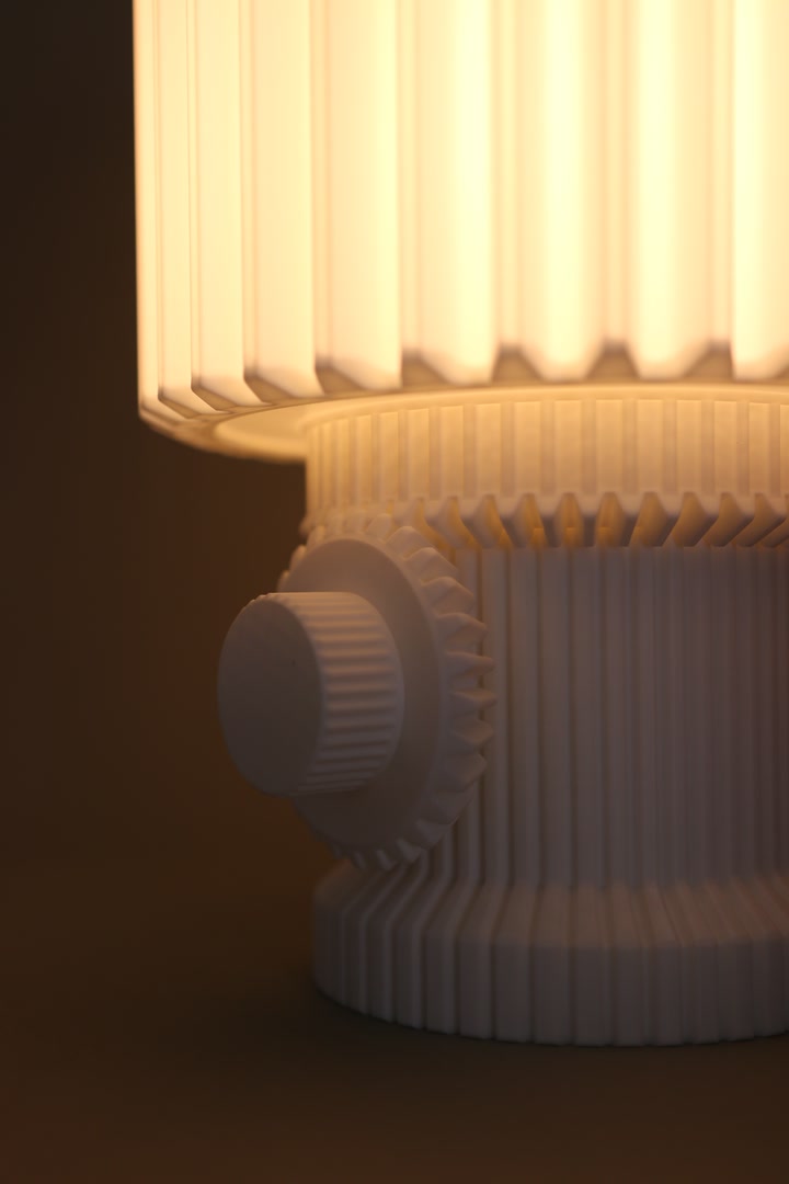 Side view of the Gear Lamp glowing against a dark background