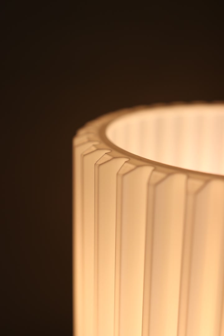 Close view of the glowing Gear Lamp shade against a dark background