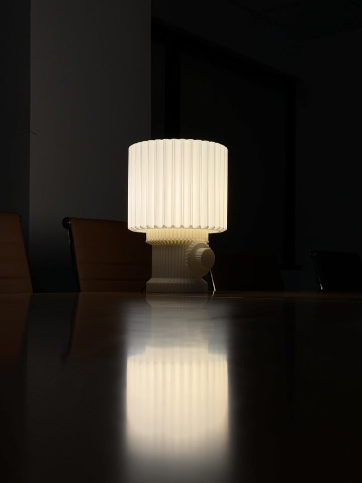 Gear Lamp glowing and reflected across a dark dining table