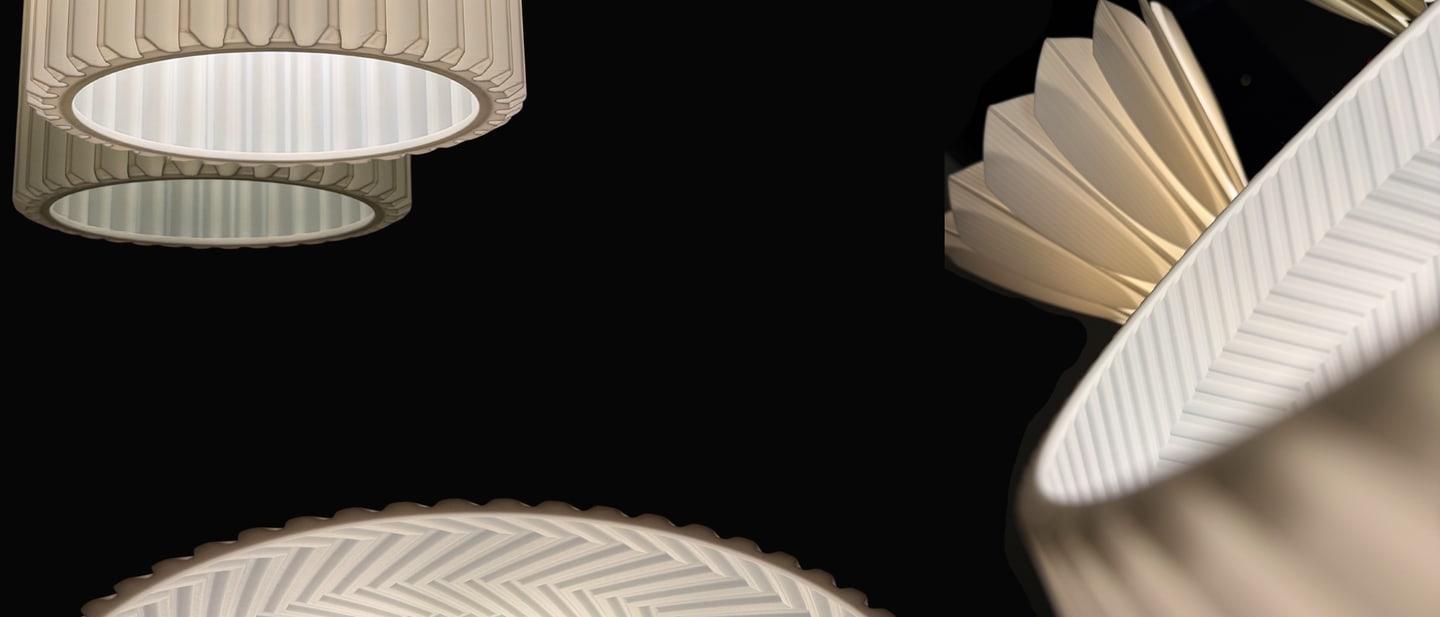 Close-up sculptural lamp forms glowing against a black background