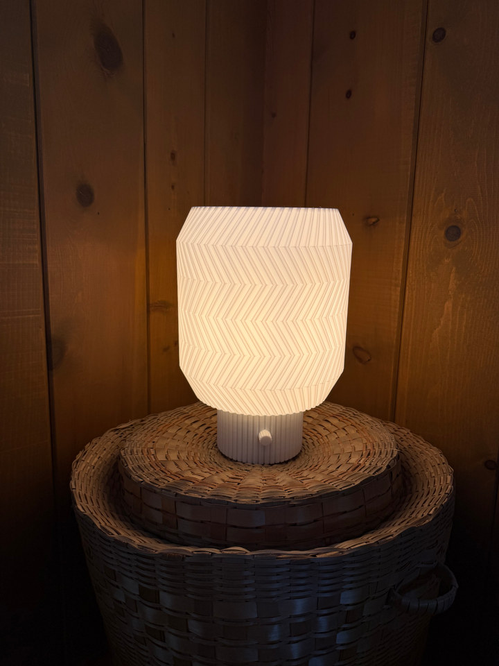 Origami Lamp glowing on stacked woven baskets