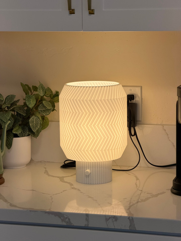 Origami Lamp glowing on a kitchen counter beside a potted plant