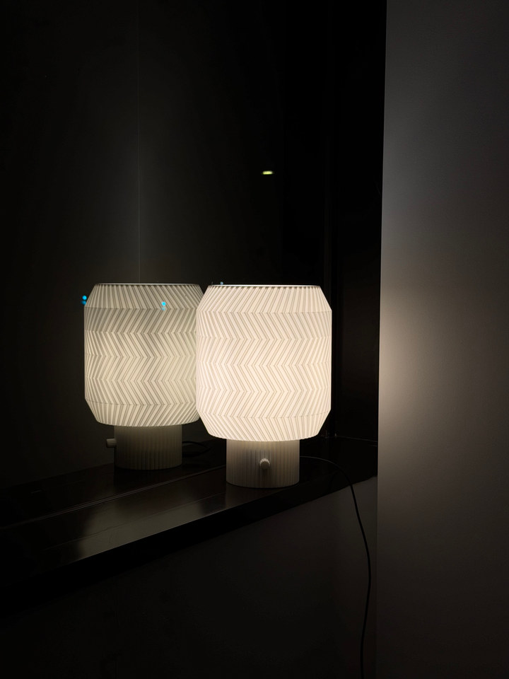 Origami Lamp and its reflection on a glossy black tabletop