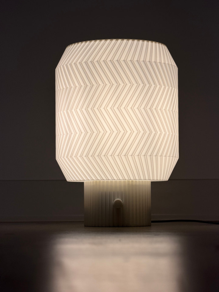 Origami Lamp glowing above its reflection on a dark tabletop