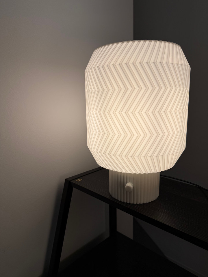 Origami Lamp glowing on a black metal side table