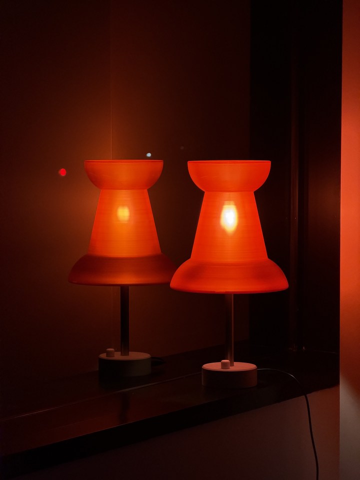 Red Pushpin Lamp and its reflection on a glossy black surface