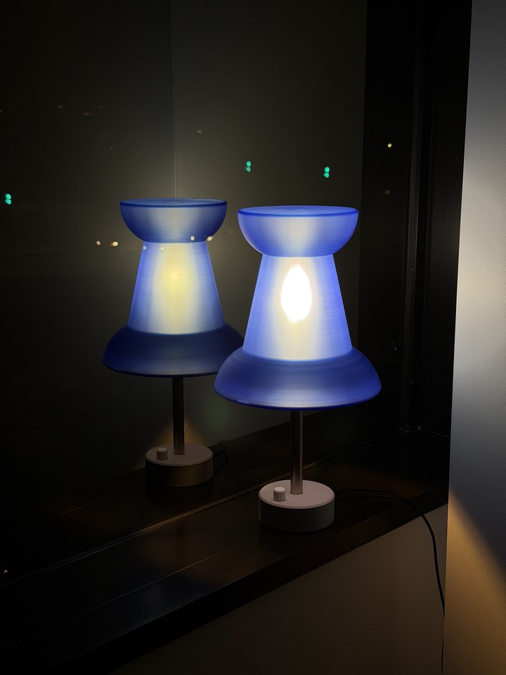 Blue Pushpin Lamp and its reflection on a glossy black surface