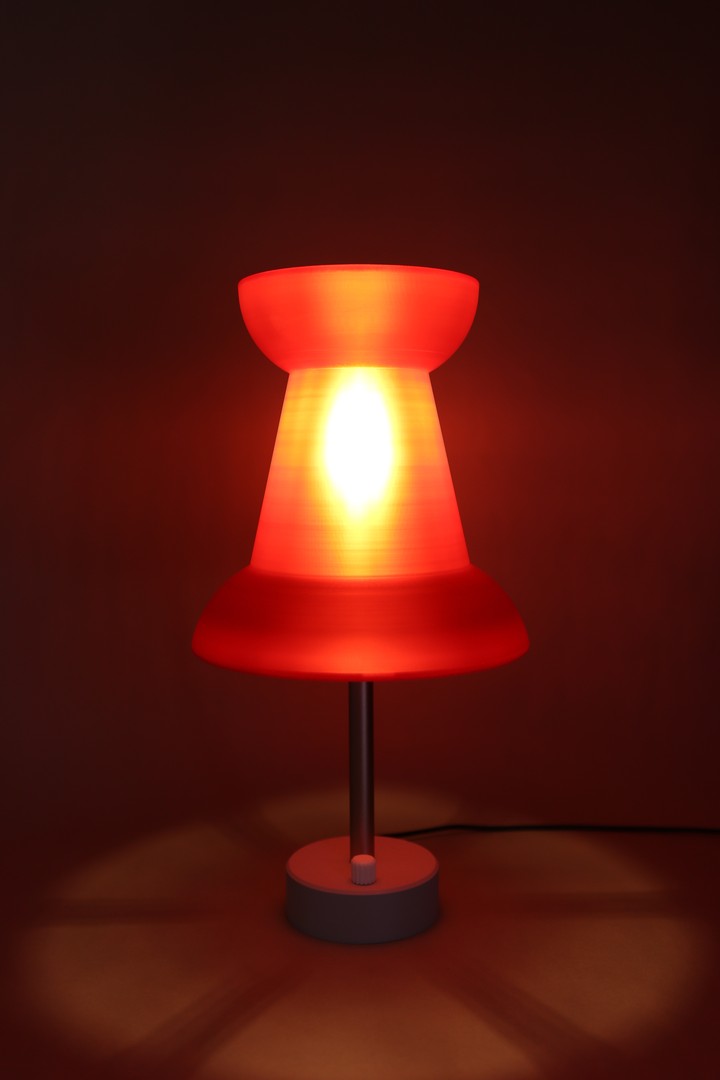 Red Pushpin Lamp glowing alone in a dark studio