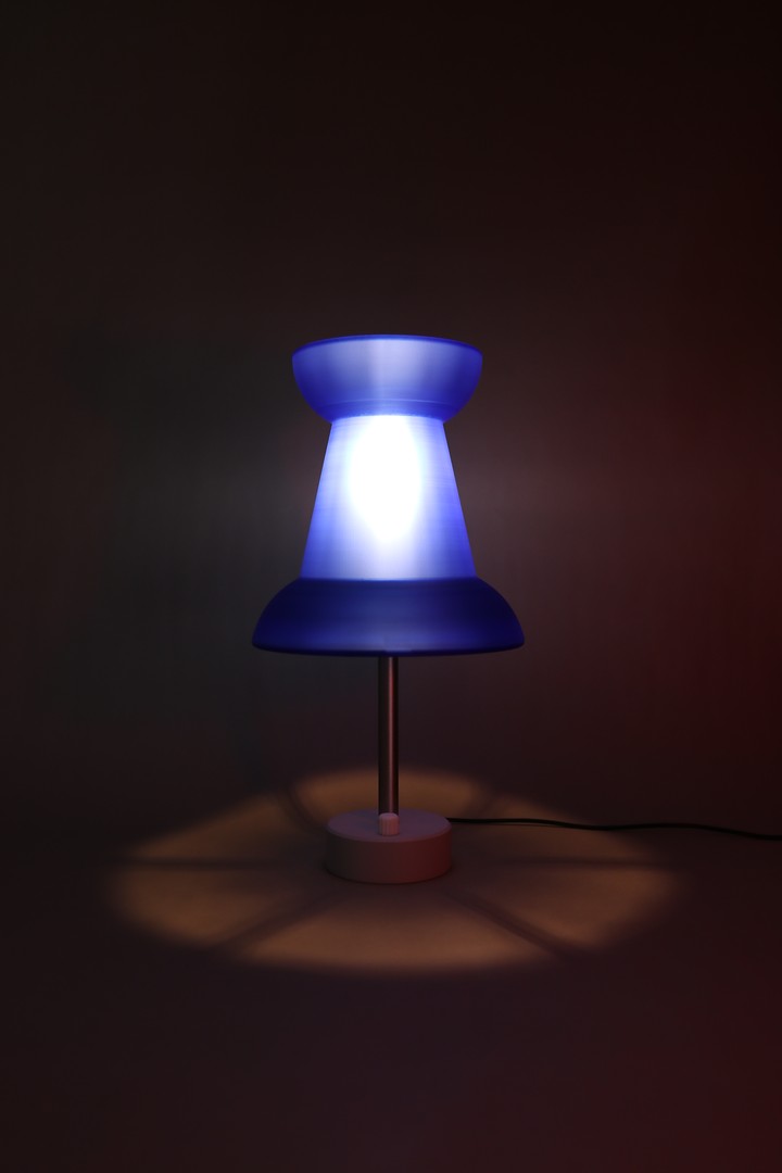 Blue Pushpin Lamp glowing alone in a dark studio