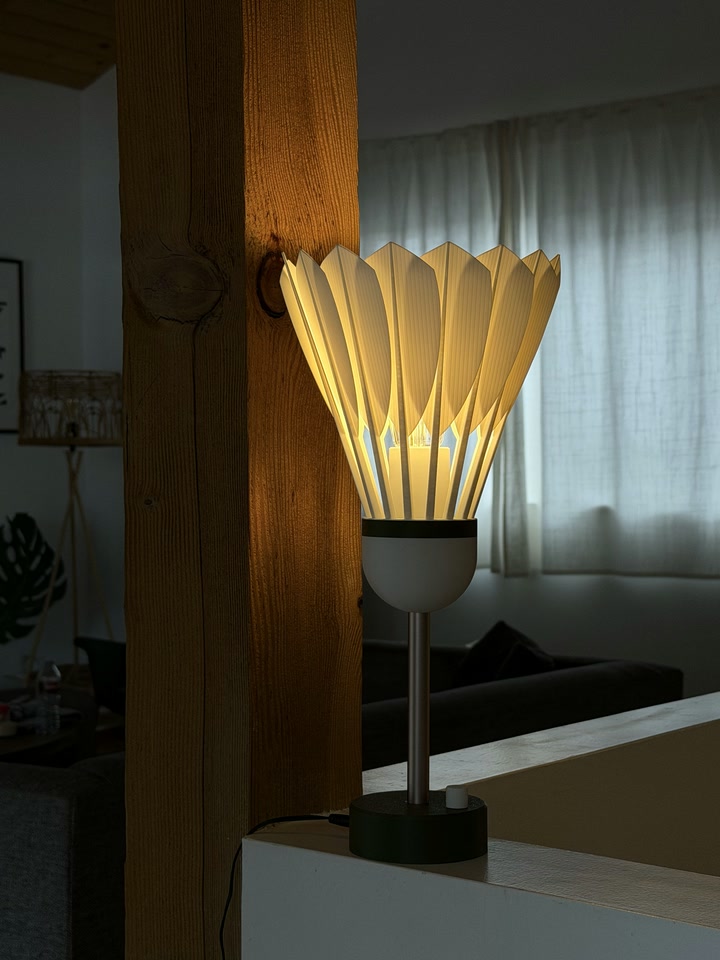 Shuttlecock Lamp glowing beside a wooden post indoors