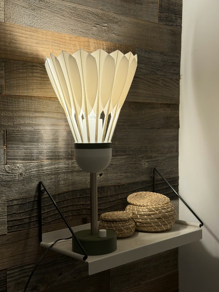 Side view of the Shuttlecock Lamp displayed on a wall shelf