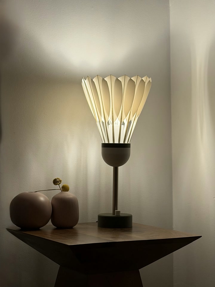 Shuttlecock Lamp casting light and shadow on a wall