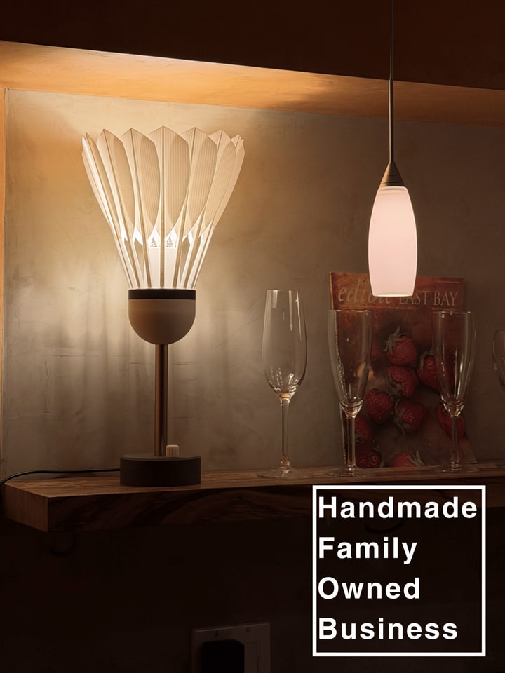 Shuttlecock Lamp displayed on a bar with an embedded handmade family owned business message